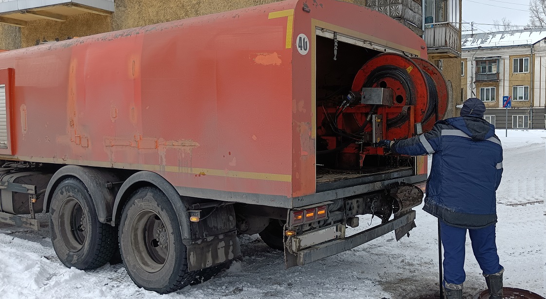 Каналопромывочная машина и работник прочищают засор в канализационной системе в Бугульме